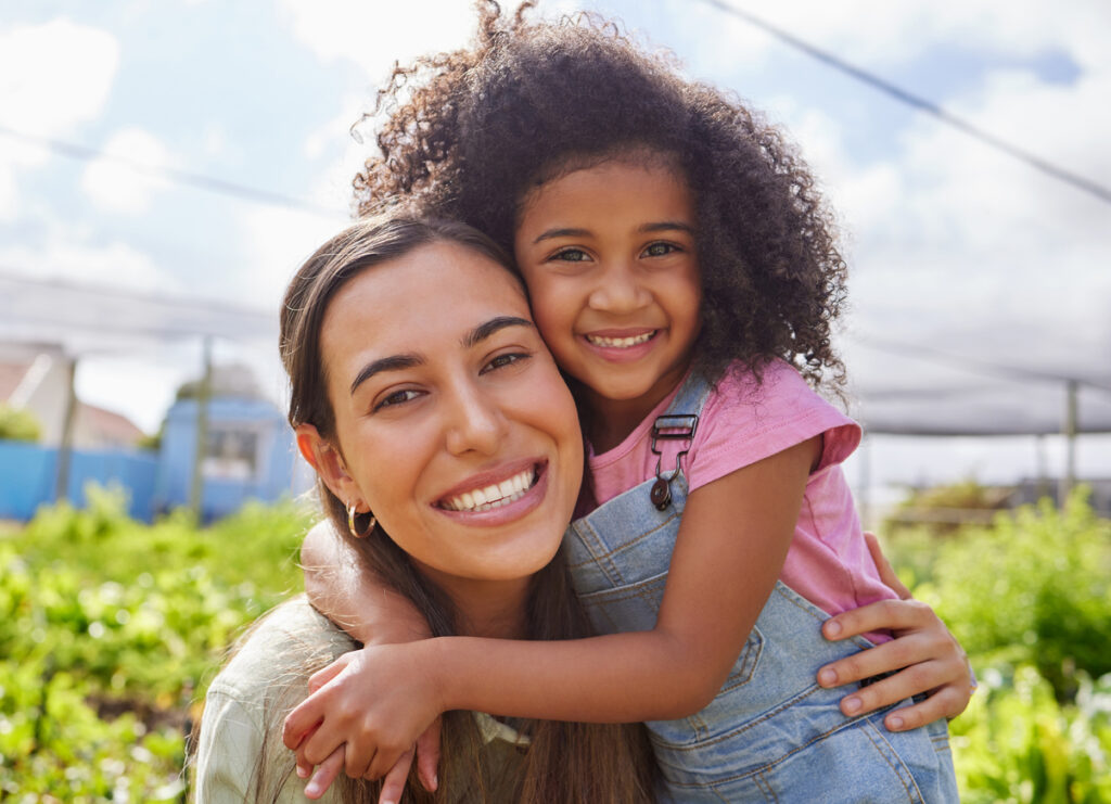 Photogenic mother and daughter embracing in the summer sun