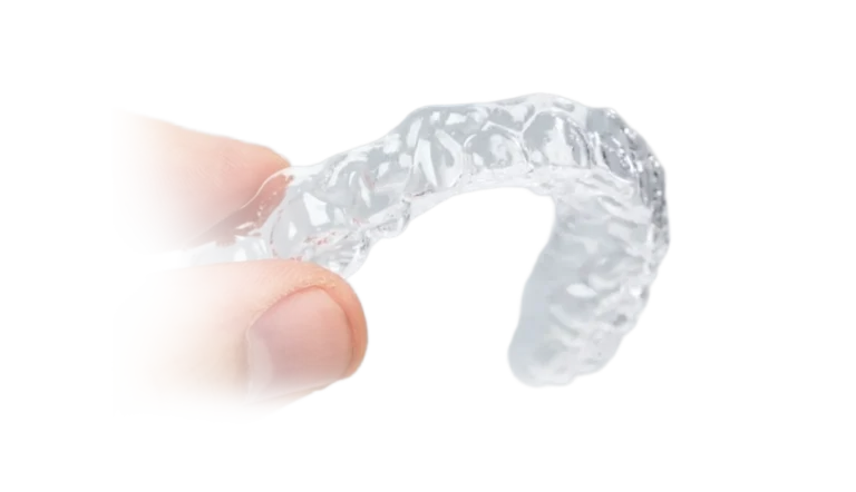 Upper Clear Tru-Tain retainer being held between a a thumb and index finger